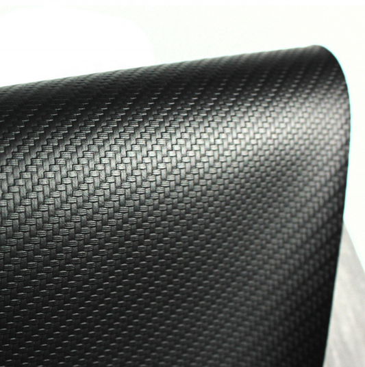 A close-up of a black carbon fiber textured material, showing a woven pattern and glossy finish, rolled over on a white background.