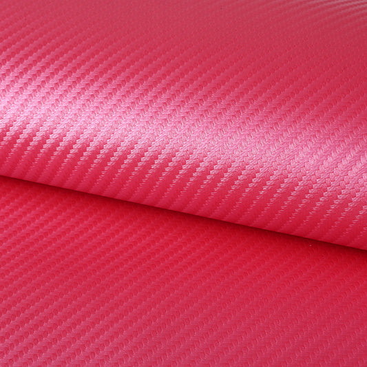 A close-up of a rolled piece of textured material with a diagonal woven pattern in bright pink and red tones.