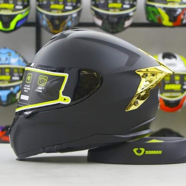 Sleek black motorcycle helmet featuring a bold gold wing accent